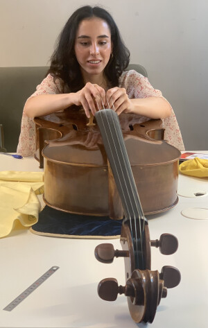 Lola zet de kam van haar cello recht.